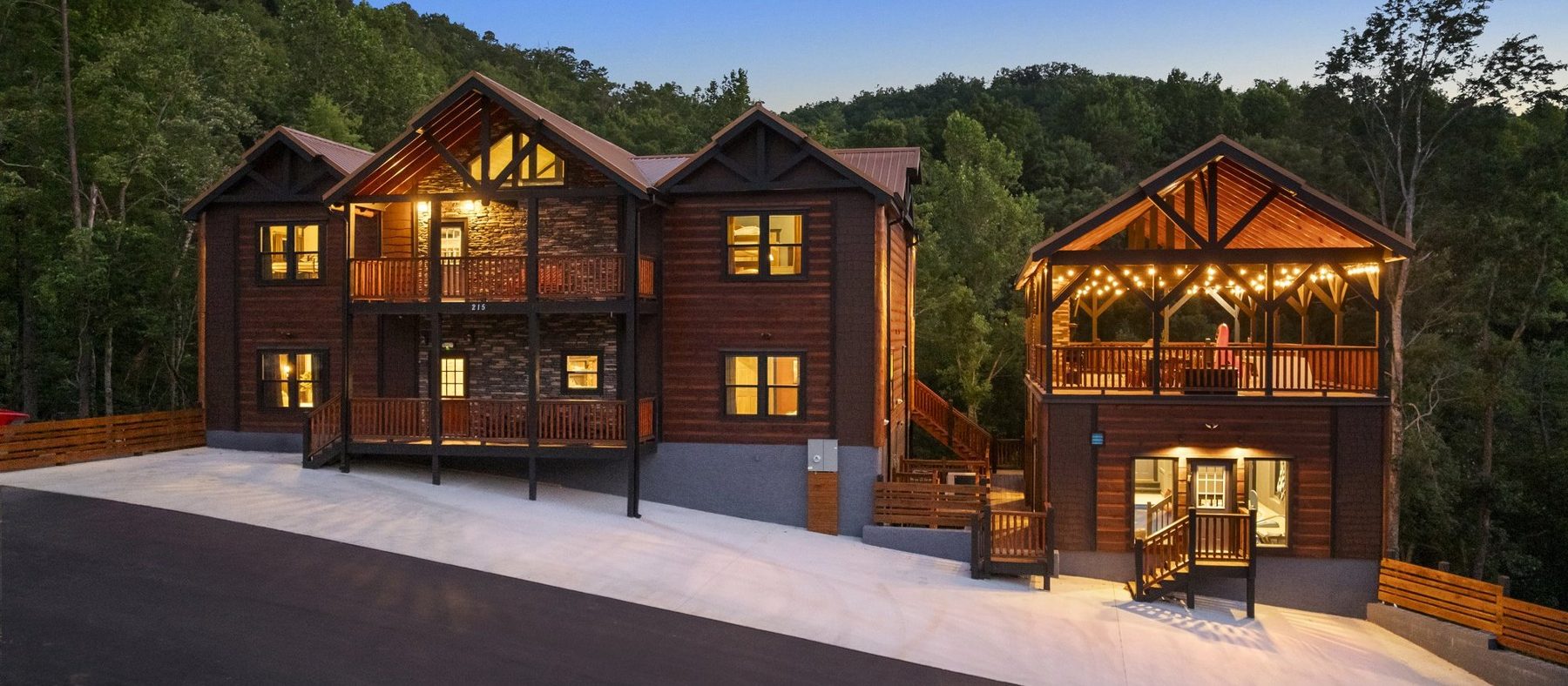 Iron Crest Social at dusk, a timber mountain lodge with a festoon-lit pavilion